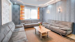 A modern living room with two grey sofas, a wooden coffee table, and a large window with patterned curtains. - Picturesque Villa in Medebach near Ski Area (Medebach)