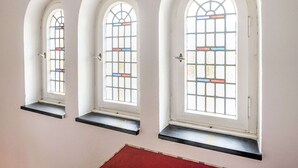 Three arched windows with stained glass, each with a small shelf below. - Picturesque Villa in Medebach near Ski Area (Medebach)