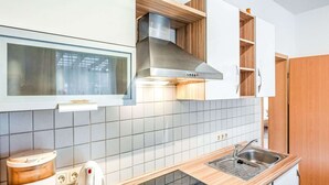 A modern kitchen with white cabinets, a stainless steel range hood, and a wooden countertop. - Picturesque Villa in Medebach near Ski Area (Medebach)