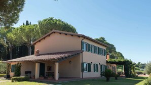Une maison à deux étages, avec un toit en tuiles, un porche abrité et une pelouse bien entretenue.