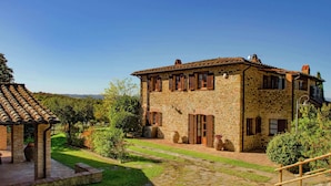 A stone building with a tiled roof, surrounded by a well-maintained garden and a cobblestone path. - Scenic Farmhouse With Pool (Citta della Pieve)