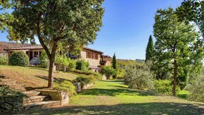 A stone house with a tiled roof, surrounded by a well-maintained garden with a stone staircase leading up to the entrance. - Scenic Farmhouse With Pool (Citta della Pieve)