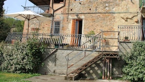 A rustic stone house with a balcony, a staircase, and a satellite dish. - Belvilla by OYO Vintage Holiday Home in Montaione (Montaione)