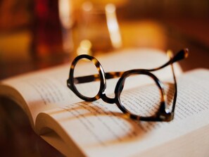 A pair of glasses resting on an open book with text visible. - Belvilla by OYO Gli Archi (Cortona)
