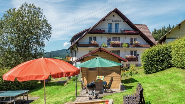 A hotel with a wooden deck, outdoor seating, and a children's play area. - Spacious Apartment in Wehrhalden near Cross Country Skiing (Herrischried)