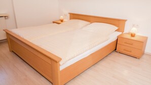 A bedroom with a wooden bed, a nightstand, and a lamp. - Spacious Apartment in Wehrhalden near Cross Country Skiing (Herrischried)