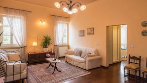 A cozy living room with a sofa, armchairs, a coffee table, and a chandelier. - Villa in Citta Della Pieve Near Lake (Citta della Pieve)