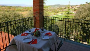 A table set for two with a view of a rural landscape. - Villa in Citta Della Pieve Near Lake (Citta della Pieve)