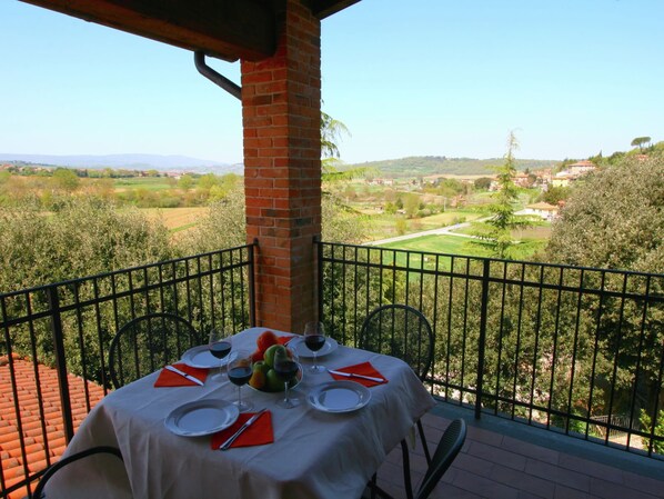 Une table dressée pour deux personnes, avec vue sur un paysage rural.