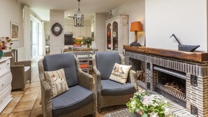 A cozy living room with two wicker chairs, a fireplace, and a skylight. - House in Zingem Near Hiking Trails (Kruishoutem)