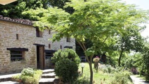 A stone building with a small garden area, steps leading up to the entrance, and potted plants. - Rural Retreat in Sassoleone (Casalfiumanese)