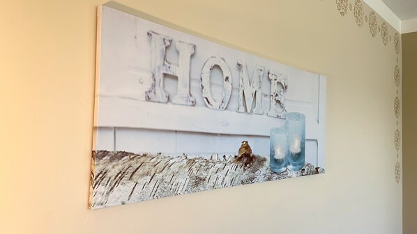 A wall-mounted sign with the word "HOME" and two glasses.