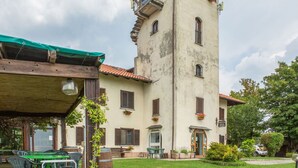 A two-story building with a balcony, a covered patio area with tables, and a sign indicating a restaurant. - Farmhouse in Verbania With Lake Views (Verbania)