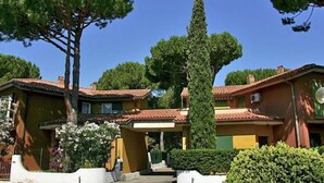 A residential area with houses featuring red-tiled roofs and green trees. - Seaside Escape in Giannella (Orbetello)