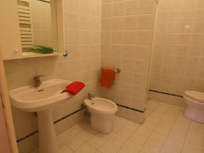 Een badkamer met een wastafel, toilet en douchehoek.
