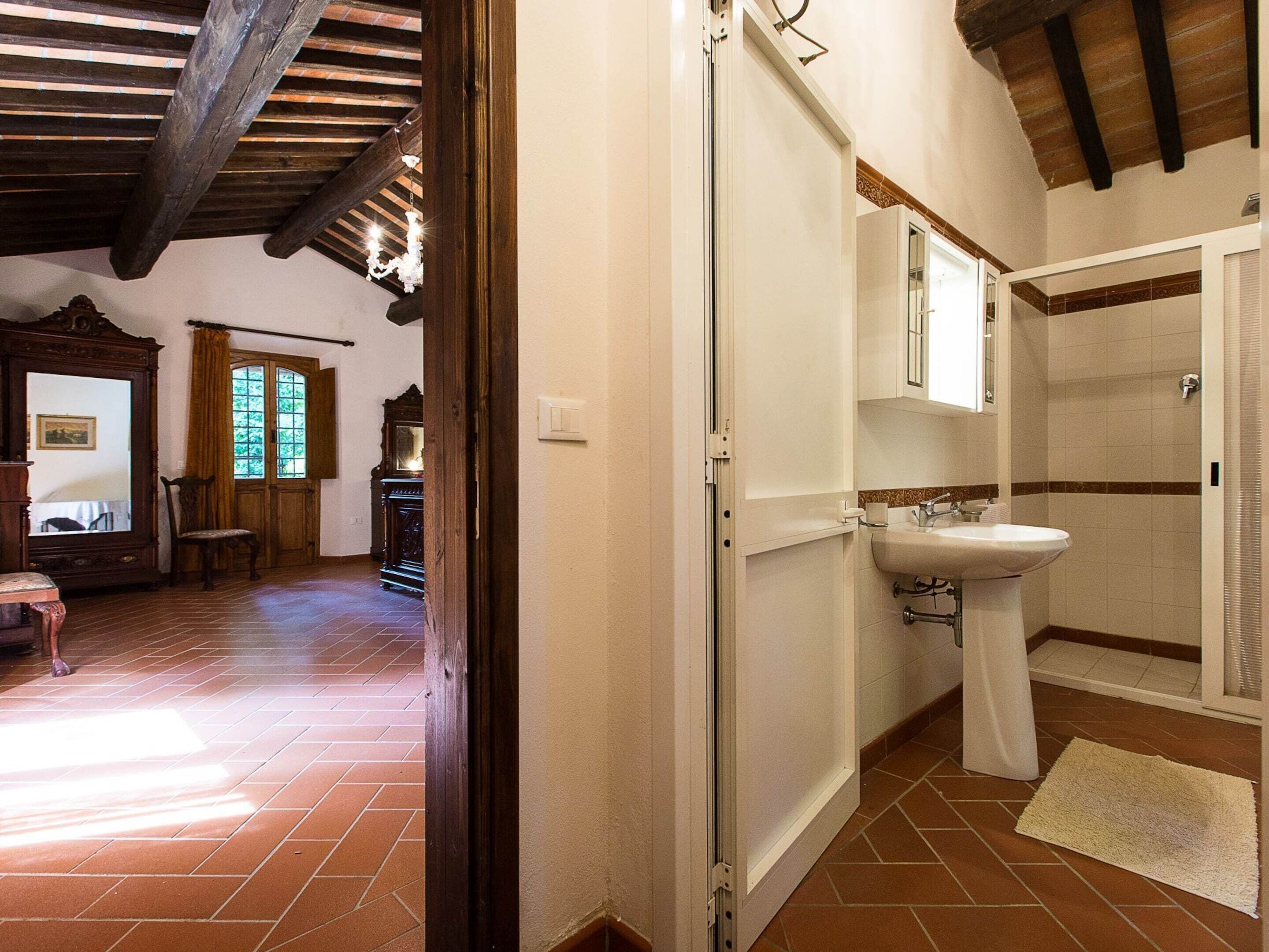 Un baño con lavamanos, espejo y ducha.