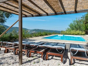 A poolside area with lounge chairs, a clear blue pool, and a view of the hills. - Belvilla by OYO Villa Carina (Serra San Quirico)