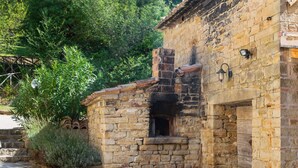A stone building with a rustic exterior, a small window, and a door. - Belvilla by OYO Villa Carina (Serra San Quirico)