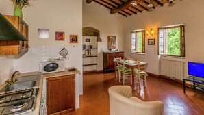 A kitchen with a stove, sink, and a dining area with chairs and a table. - Farmhouse Montepulciano Near Vineyards Pool (Montepulciano)