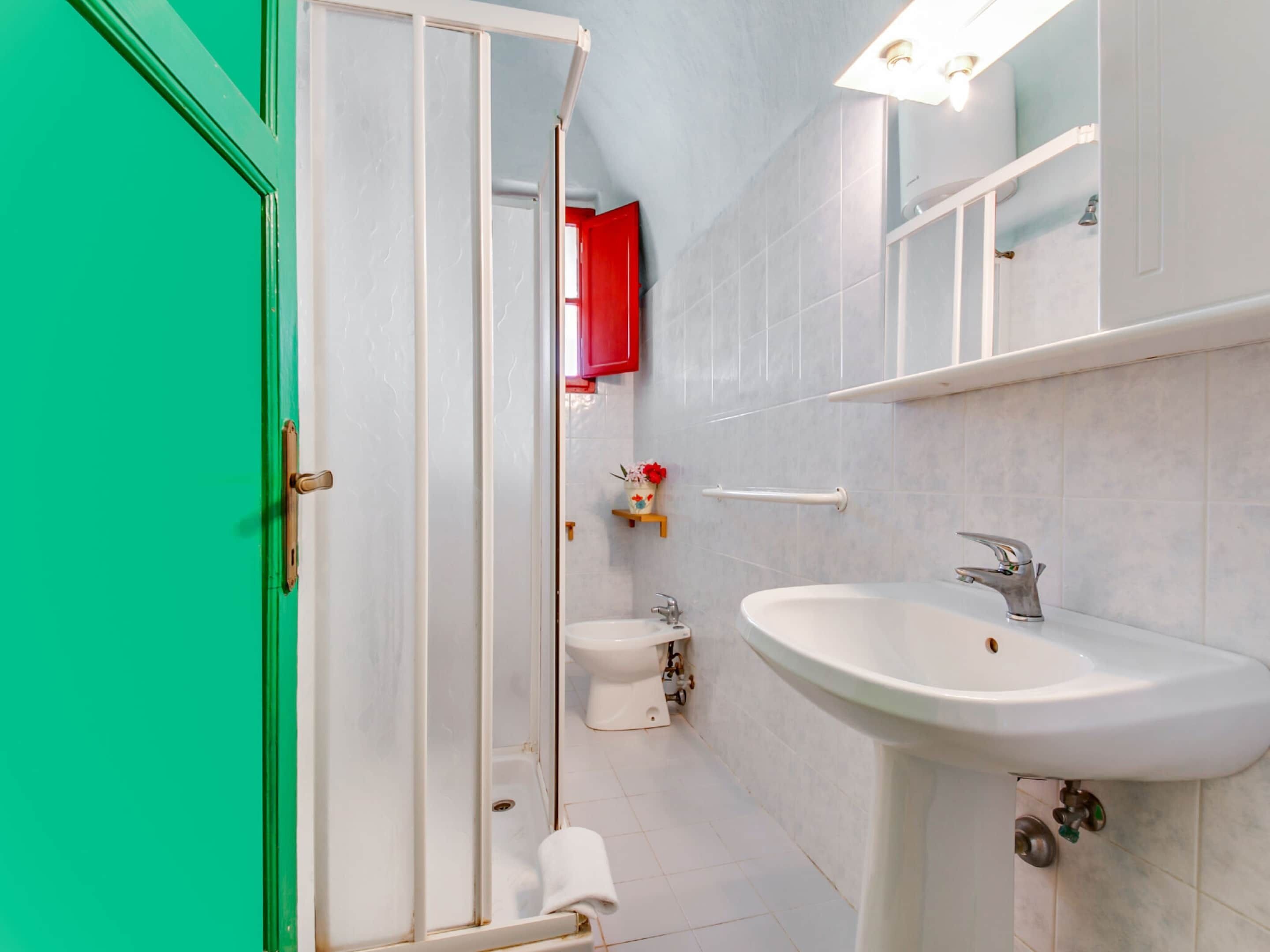 A bathroom with a shower, toilet, and sink.