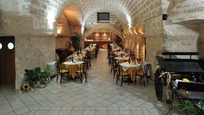 A restaurant with a vaulted ceiling, multiple tables and chairs, and a bar area. - Belvilla by OYO Tramonto di Salento Grande (Torricella)