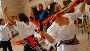 A group of people dancing in a room with stone walls and a tiled floor. - Farm Near the Beautiful Ionian Sea, in the Beautiful Salento (Torricella)