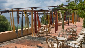 An outdoor seating area with wicker furniture and a clothesline with various garments. - Mansion in Capo Vaticano With Sea Views (Ricadi)