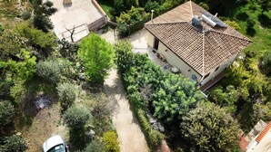 An aerial view of a house with a tiled roof, surrounded by dense greenery and a gravel path. - Holiday Home in Lido di Noto Near Beach (Noto)