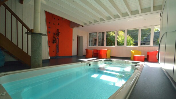 Una piscina interior con vista despejada al techo y a las ventanas.