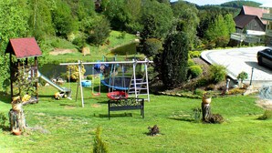 A playground with swings, a slide, and a trampoline.