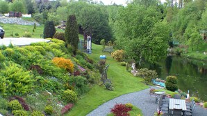 A garden with a pond, a gazebo, and a seating area with tables and chairs.