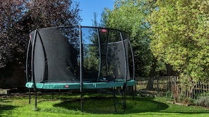 A trampoline with a safety net in a backyard. - Spacious Countryside Farm Stay (Vleteren)