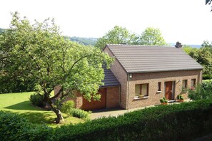 A brick house with a sloped roof, a front porch, and a well-maintained lawn. - Modern Holiday Home in Stavelot With Fireplace (Stavelot)