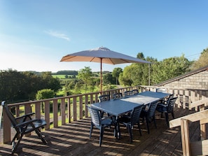 An outdoor deck with a table and chairs, a wooden railing, and a view of the countryside. - Holiday Home in Ardennes With Nature Views (Marche-en-Famenne)