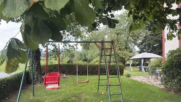 A playground with swings and a climbing structure.