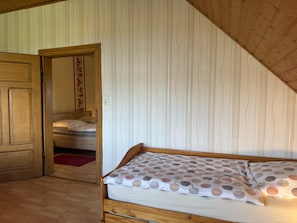 A bedroom with a wooden bed, a wooden door, and a striped wallpaper. - Landhaus Nahe Sababurg Schloss (Trendelburg)