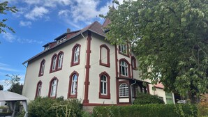 A large, multi-story building with a symmetrical facade, multiple windows, and a red-tiled roof. - Landhaus Nahe Sababurg Schloss (Trendelburg)