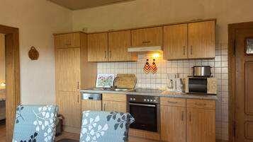 A kitchen with wooden cabinets, a Bosch oven, a coffee maker, and a toaster.