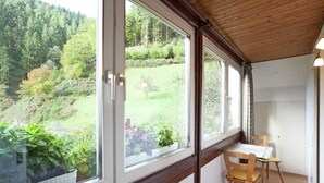A room with large windows, wooden ceiling, and a view of a green landscape. - Holiday Home Near the Forest in Oppenau (Oppenau)