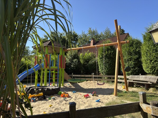 A playground with a slide, climbing structures, and sand. - Holiday Home in Germany With Garden Terrace (Brakel)