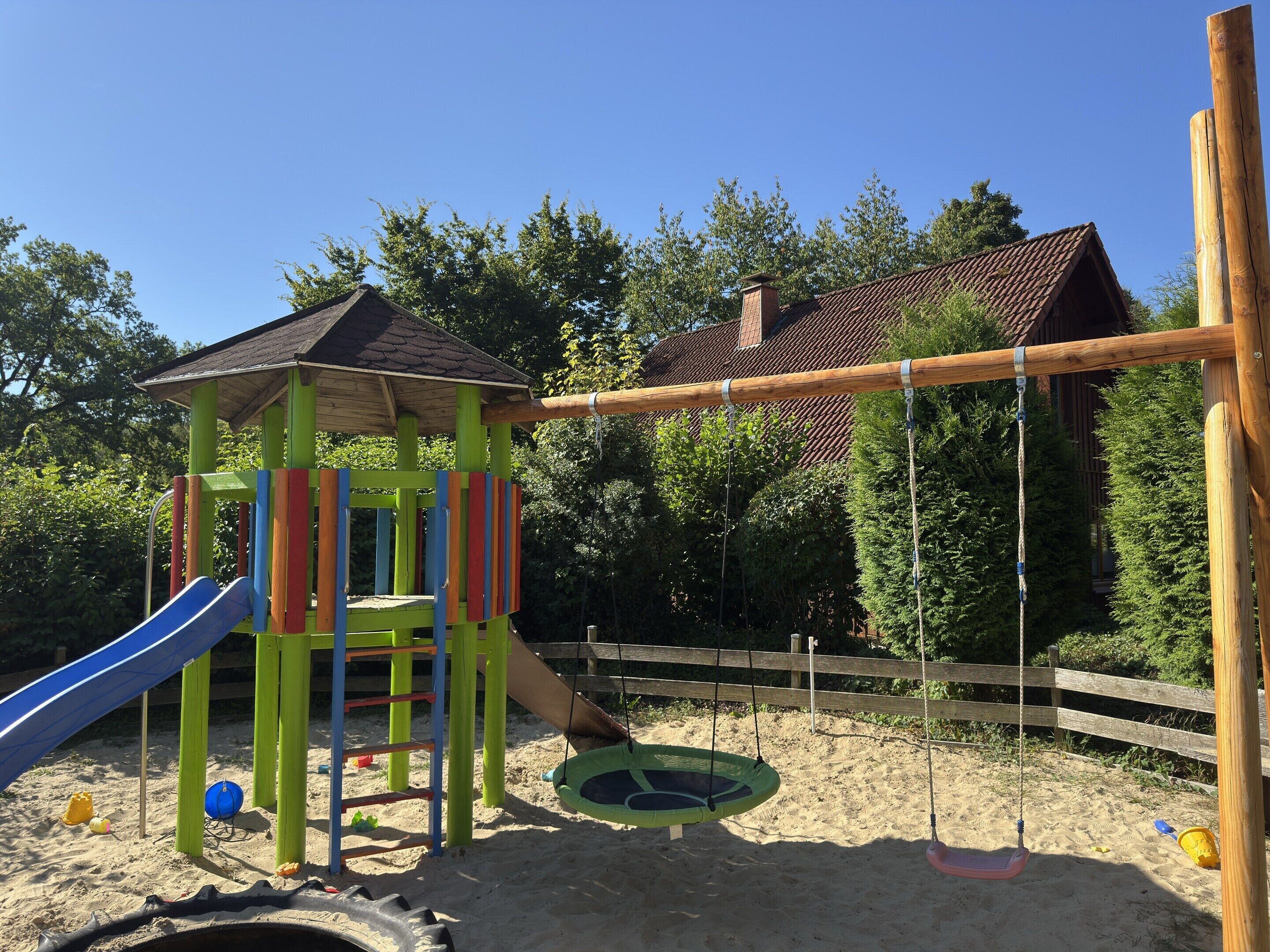 Un parc infantil amb tobogan, elements per escalar i cadira aeri.