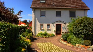 A two-story house with a tiled roof, a front door, and a small porch. - Ferienwohnung mit Sauna (Nieheim)