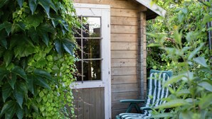 A wooden cabin with a door, a window, and a chair. - Ferienwohnung mit Sauna (Nieheim)