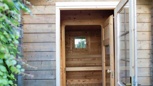A wooden cabin with a central door leading to a staircase. - Ferienwohnung mit Sauna (Nieheim)