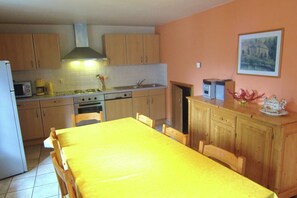 Eine Küche mit Holzausstattung, einem gelben Tisch und einem Bild an der Wand.
