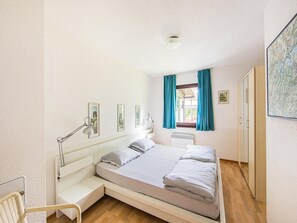 A bedroom with a bed, a desk, a chair, and a window with curtains. - Spacious Apartment in Frankenau Hesse near Forest (Frankenau)