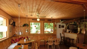 Ein Holzblockhaus-Innenraum mit Essbereich, Küche und Bar.