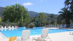 Poolbereich mit Liegestühlen und Bergblick.