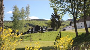 A rural setting with a large barn, a white building, and a grassy hill. - Splendid Holiday Home in Untervalme near Ski Area (Bestwig)