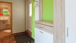 A bathroom with a wooden vanity, a sink, and a green wall. - Gemutliches Ferienhaus in Sebnitz (Sebnitz)